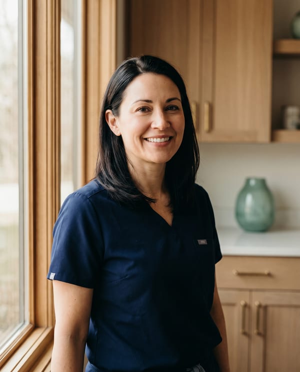 Portrait of Dr. Elena Marsh, founder of Harborlight Family Dentistry, by a window in a treatment room